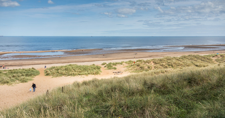 mother and child walking onto Crimdon Beach